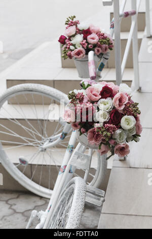 Kreativen Blumenstrauß bunte künstliche auf alten weißen Fahrrad. Raum in der Zone Unschärfe Zusammensetzung und selektiven Fokus Stockfoto