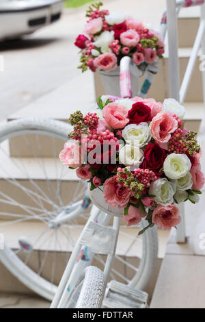 Kreativen Blumenstrauß bunte künstliche auf alten weißen Fahrrad. Raum in der Zone Unschärfe Zusammensetzung und selektiven Fokus Stockfoto