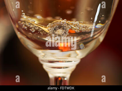 Ein Verlobungsring in einem Glas Champagner. Stockfoto