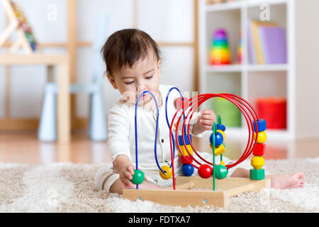 lustiges Kind spielt mit indoor pädagogisches Spielzeug Stockfoto