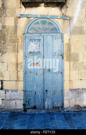 Blaue verwitterte Tür in ein Haus in einem Kalkstein-Gebäude Stockfoto