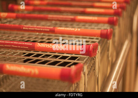 Eine Nahaufnahme von Sainsbury Supermarkt Trolleys / Wagen geparkt in Folge Stockfoto