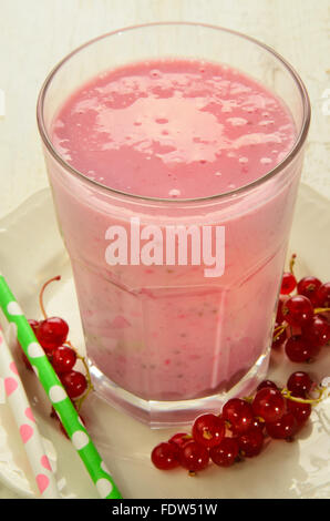 Milchshake mit roten Johannisbeeren und Stroh Stockfoto