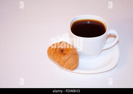 Tasse Kaffee und Vanille Croissant mit Schokolade. Frühstück sehr lecker und aromatisch. Stockfoto