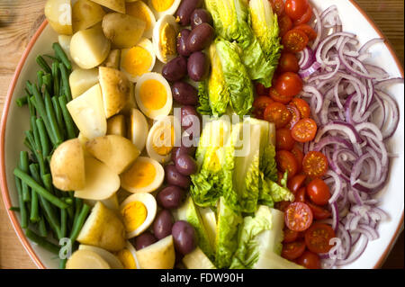 Salat mit gekochten Eiern, Tomaten, Salat, Oliven, grüne Bohnen, Zwiebeln und Salzkartoffeln Stockfoto