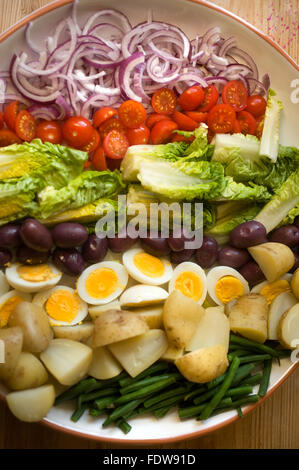 Salat mit gekochten Eiern, Tomaten, Salat, Oliven, grüne Bohnen, Zwiebeln und Salzkartoffeln Stockfoto