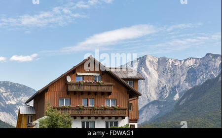 Österreichische Alpine Idylle mit traditionellen Holzhaus und hohen Bergen im Hintergrund, mit Textfreiraum Stockfoto