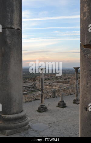 Volubilis Ruinen in Marokko Sonnenuntergang, römische Ruinen in der Nähe von Fez, durch Säulen malerische ausgeglichen Stockfoto