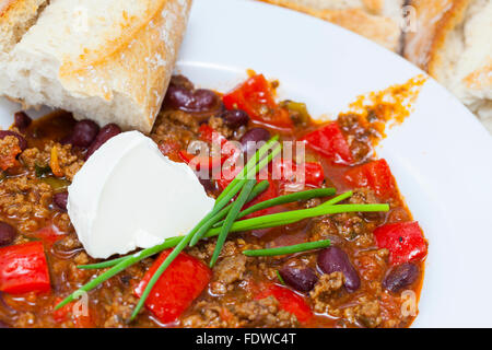 köstliche hausgemachte Chili Con Carne mit Brot und Sauerrahm Stockfoto