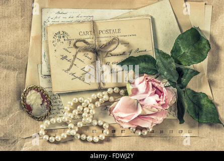 Alte Briefe, Postkarten und Vintage Accessoires. Papierhintergrund mit trockener rose Blume. Retro-Stil getönten Bild Stockfoto