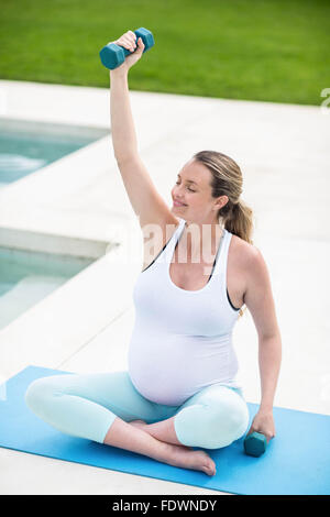 Schwangere Frau Hanteln heben Stockfoto