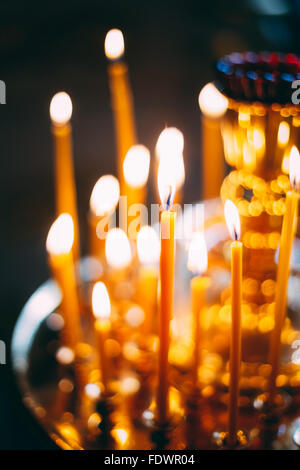 Gruppe von brennenden Kirche Kerzen auf dunklem Hintergrund Stockfoto