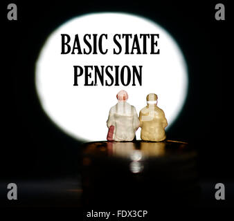 Miniatur Figur Rentner sitzen auf Münzen vor, wird ein Spotlight angezeigt das Wort Basic State Pension Konzept Stockfoto