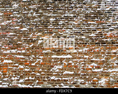 Breiten roten Backsteinmauer mit Schneeflocken bedeckt Stockfoto