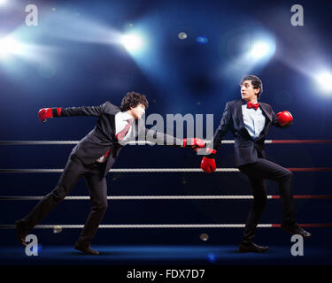 Zwei junge Unternehmer Boxen Againts dunklen Hintergrund. konzeptuelle collage Stockfoto