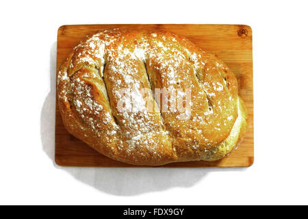 Ein frisch gebackenes Brot auf einem Holzbrett vor weißem Hintergrund fotografiert Stockfoto