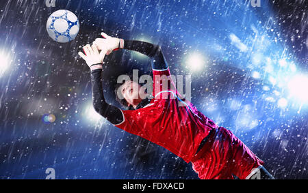 Torwart fängt den Ball. Im Stadion, im Rampenlicht. Stockfoto