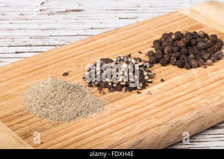 Vielzahl von Paprika auf Holzplatte Stockfoto