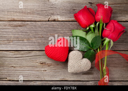 Rote Rosen und Herzen zum Valentinstag auf hölzernen Hintergrund. Draufsicht mit Textfreiraum Stockfoto