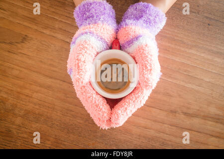 Behandschuhten Hände halten Kaffee, stock Foto Stockfoto