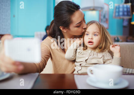 Hübsche Frau machen Selfie beim Tee im Café mit ihrer Tochter Stockfoto