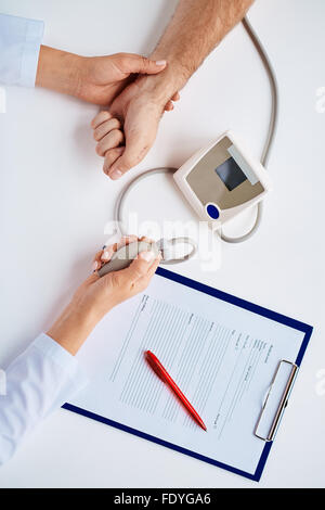 Händen der Arzt misst Blutdruck des Patienten Stockfoto