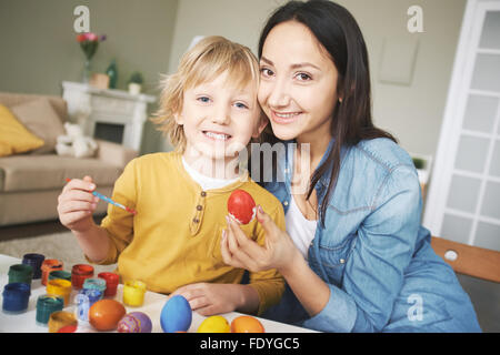 Mutter und Sohn bemalen von Ostereiern zu Hause Stockfoto