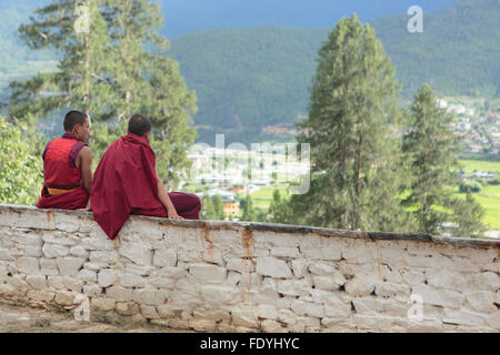 Zwei Mönche sitzen an einer Wand in Thimphu, Bhutan Stockfoto