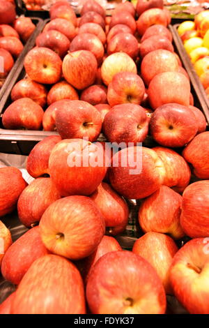 Handvoll frische rote Äpfel auf Boxen im Supermarkt Stockfoto