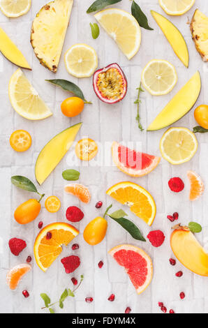 Sammlung von ganze und geschnittene gelbe, orange und rote Frischobst auf weißem rustikalen Hintergrund Stockfoto