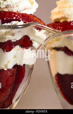 Eine Nahansicht des frischen Erdbeeren mariniert im Hafen mit Chantilly Sahne in Eisbecher Gläser garniert mit frischer Minze. Stockfoto