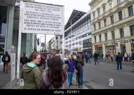 Touristen am "Checkpoint Charlie" Berlin in der Nähe von Zeichen, die Menschen zu informieren, dass sie den amerikanischen Sektor betreten. Stockfoto