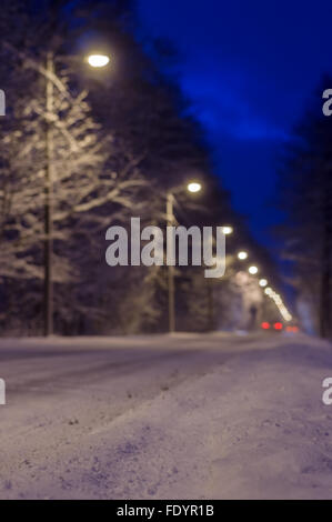Verschwommenes Bild der verschneiten Straße und Auto Rückleuchten Stockfoto