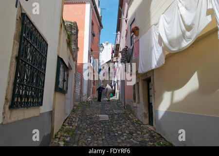 Lissabon, PORTUGAL - 23. Januar 2016: Nicht identifizierten Personen auf einer Straße mit bunten Trocknen von Kleidung in der Alfama, Lissabon. Stockfoto