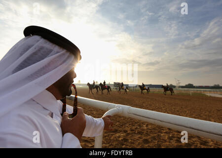 Dubai, Vereinigte Arabische Emirate, Arabische Pferde und Reiter beobachtet während des Trainings auf der Rennbahn Stockfoto