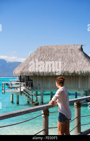 Frau an einem Anlegesteg der Wasserbungalows von Sofitel Hotel, Moorea, Gesellschaftsinseln, Französisch-Polynesien Stockfoto