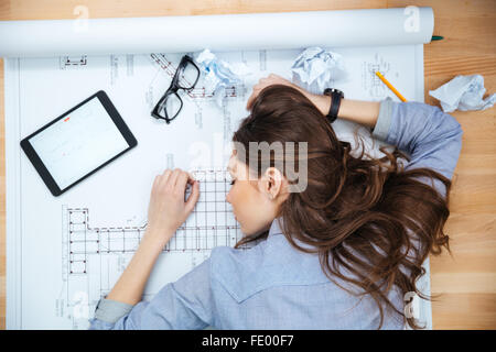 Draufsicht der müde junge Frau liegen und schlafen auf Blaupause Stockfoto