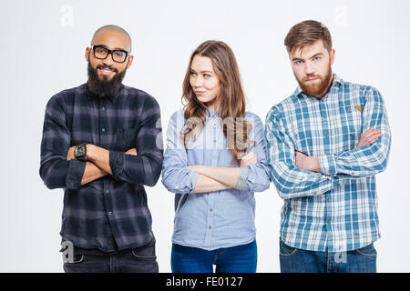 Zwei junge bärtige selbstbewusste Männer und eine hübsche junge Frau, die Arme gekreuzt Stockfoto