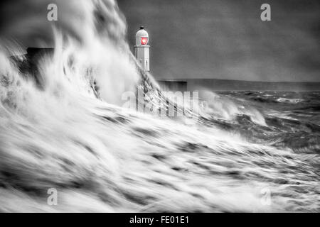 Schwarz und Weiß von grossen Wellen in die Kaimauer Kollision als Sturm hits Leuchtturm, Porthcawl. In Bridgend, Südwales, Vereinigtes Königreich Stockfoto