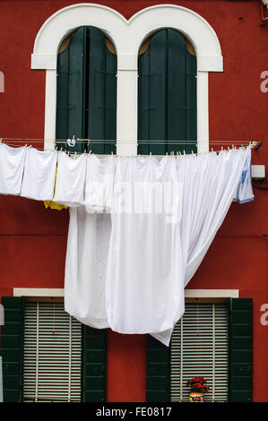 Weiß Bett gegen grüne Wand und Vintage, grau Sessel auf gestreiften
