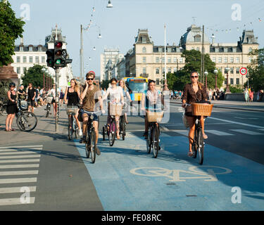 Junge Dänen, die auf dem Dronning Louises Bro im sonnigen Kopenhagen, Dänemark, mit dem Fahrrad durch die Stadt fahren Stockfoto