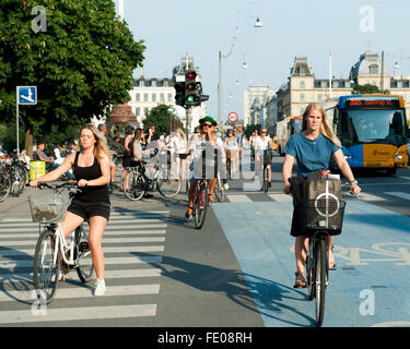 Junge Dänen, die auf dem Dronning Louises Bro im sonnigen Kopenhagen, Dänemark, mit dem Fahrrad durch die Stadt fahren Stockfoto