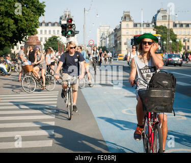 Junge Dänen, die auf dem Dronning Louises Bro im sonnigen Kopenhagen, Dänemark, mit dem Fahrrad durch die Stadt fahren Stockfoto