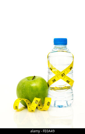 Flasche Wasser verpackt in gelb imperial Tape measure mit grünem Apfel und isoliert auf weißem Hintergrund mit Textfreiraum Stockfoto