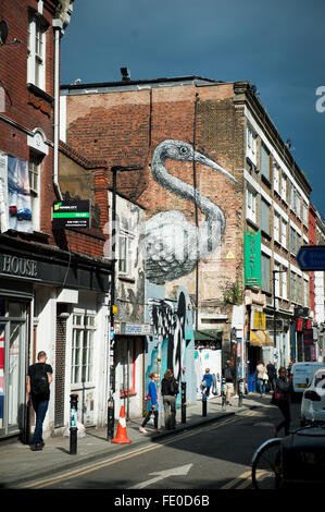 Graffiti des Vogels auf dem Gebäude in der Brick Lane in East London, Großbritannien. Zuhause für viele Curryhäuser Stockfoto