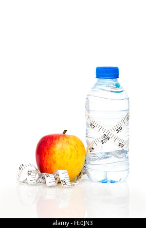 Flasche Wasser verpackt in weiße Kaiserliche Maßband mit roten Apfel isoliert auf weißem Hintergrund mit Textfreiraum Stockfoto