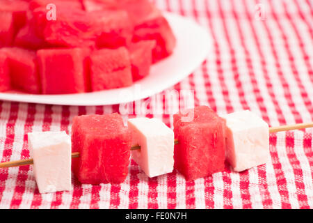 Wassermelone und weiße Käsestücke auf Sticks mit Wassermelone Platte Stockfoto