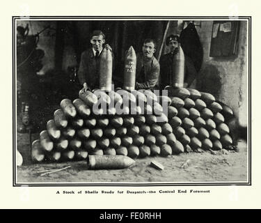 Arbeitnehmer in einem ersten Weltkrieg Munition Fabrik hinter einen Haufen von abgeschlossenen Artillerie-Granaten Stockfoto