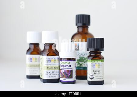Flaschen von verschiedenen ätherischen Ölen vor einem weißen Hintergrund. Stockfoto