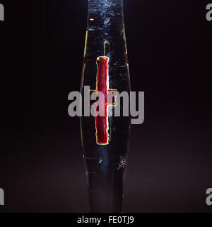 Kreuz auf Glas als christliches Symbol, lackiert in rot, ein Kerzenständer Teil. Stockfoto